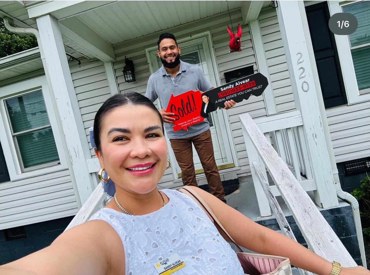 Sandy Alvear with client holding Sold sign at home